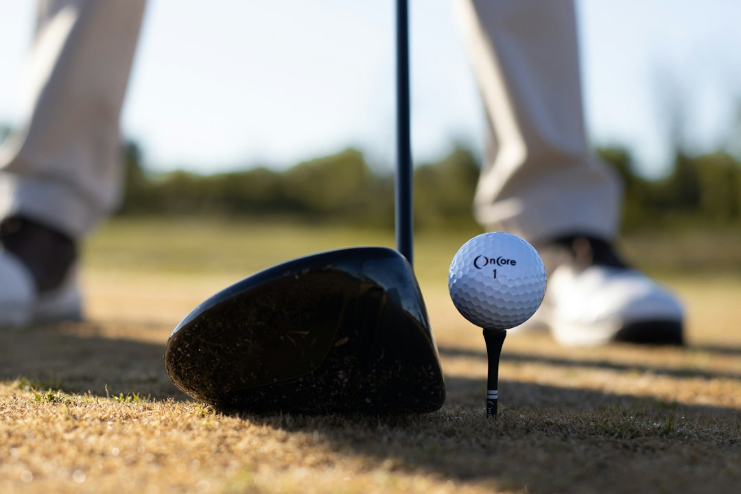 A golf ball sitting beside a driver head
