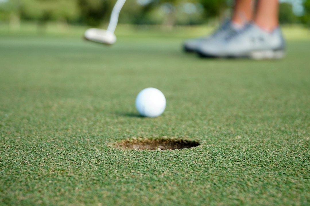 A golf ball rolling towards the hole on a putting green after a putt