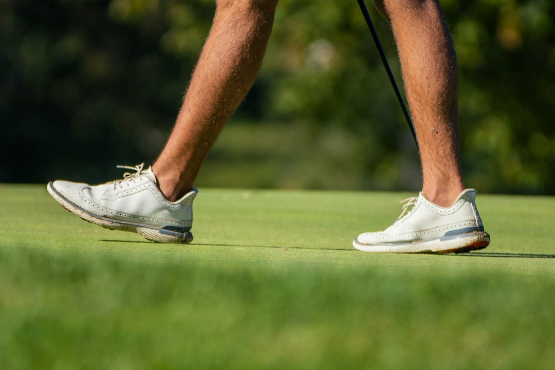 A golfer walking on a green with a club