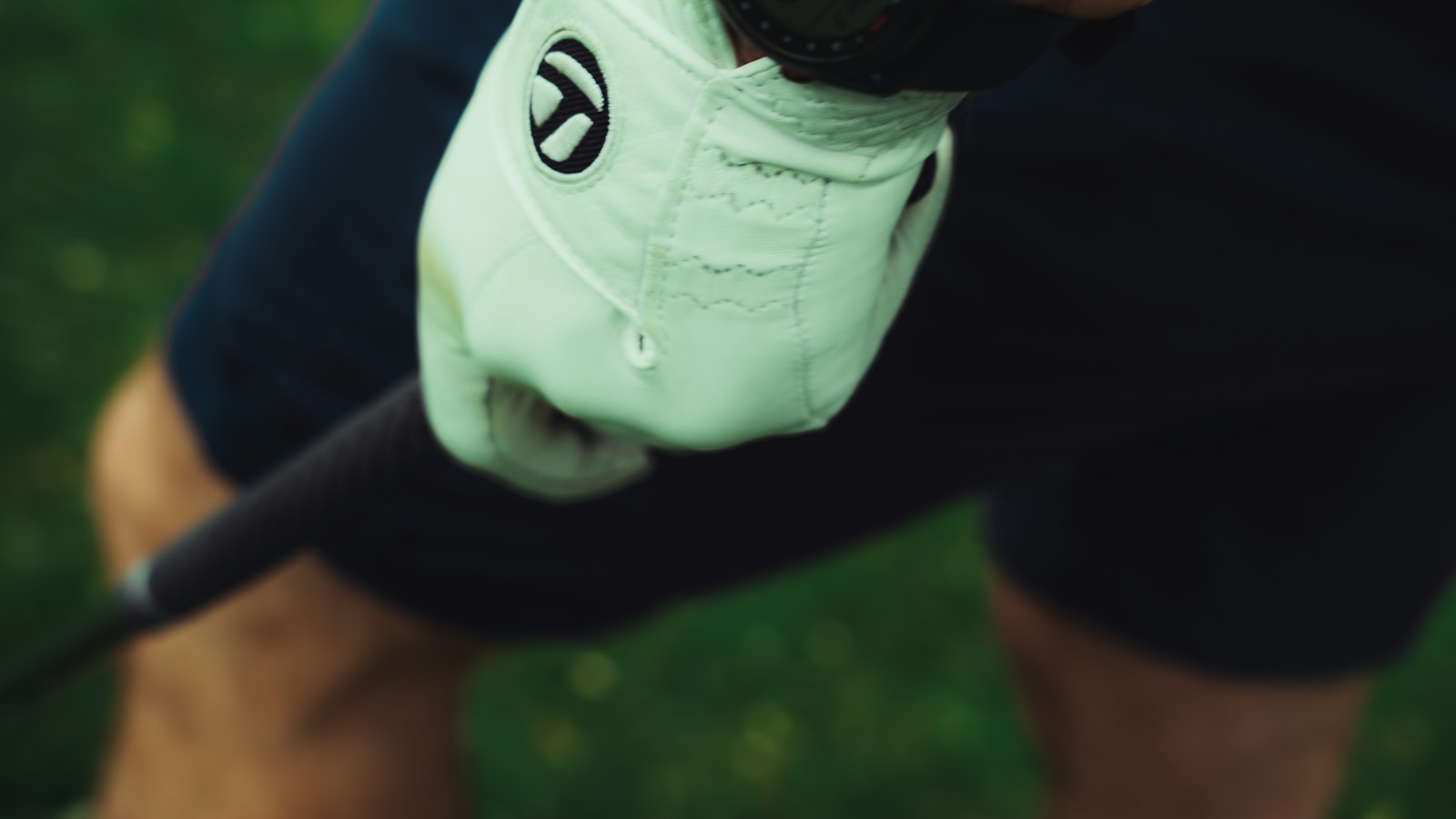A golfer's gloved hand gripping a golf club